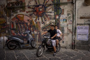 Two kids are seen on a scooter in a street of the “Rione Sanità” in Naples, Italy on June 17, 2020. Popular neighborhoods are those that more than others are suffering from the economic crisis generated by the coronavirus. The rate of poverty and unemployment that was higher than the national average in Southern Italy even before the pandemic, increased following the lockdown imposed by the government to counter the spread of the coronavirus, which blocked the country’s economy for more than two months.