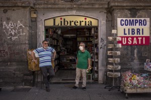 Two men are seen outside a library in Dante square in Naples, Southern Italy on June 15, 2020.