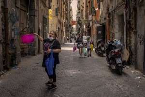 A woman takes items from a basket in the “Quartieri Spagnoli” in Naples, Italy on June 16, 2020. Popular neighborhoods are those that more than others are suffering from the economic crisis generated by the coronavirus. The rate of poverty and unemployment that was higher than the national average in Southern Italy even before the pandemic, increased following the lockdown imposed by the government to counter the spread of the coronavirus, which blocked the country’s economy for more than two months.