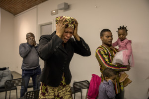 People pray during the Sunday mass celebrated by Princess Inyang Okokon inside a Pentecostal church in Asti, Northern Italy on January 12, 2020.