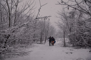 Migrants with sleeping bags and blankets cross the snow-covered fields to return to their shelter, found in the rubble of an abandoned factory in Bihac, Bosnia and Herzegovina on January 25, 2021. Lots of migrants avoid staying inside the Bosnian official refugee camps because of the hard conditions in which they are forced to live and also because the people hosted in the official camps  cannot go out freely.