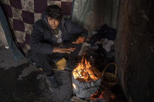 Ataullah, 25 years old from Afghanistan warms up near a fire inside an abandoned building in Bihac, Bosnia and Herzegovina on January 27, 2021. Ataullah has been in Bosnia for 7 months and has tried the “game” 8 times to continue his journey to Northern Europe and join his family who live in Germany. The Croatian police has always intercepted him and once broke his phone and glasses. Lots of migrants avoid staying inside the Bosnian official refugee camps because of the hard conditions in which they are forced to live and also because the people hosted in the official camps  cannot go out freely.