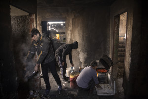 Migrants prepare bread inside an abandoned building in Bihac, Bosnia and Herzegovina on January 27, 2021. Lots of migrants avoid staying inside the Bosnian official refugee camps because of the hard conditions in which they are forced to live and also because the people hosted in the official camps  cannot go out freely.