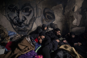 Migrants from Afghanistan and Pakistan watch a football match on a smartphone inside an abandoned building in Bihac, Bosnia and Herzegovina on January 21, 2021. Lots of migrants avoid staying inside the Bosnian official refugee camps because of the hard conditions in which they are forced to live and also because the people hosted in the official camps  cannot go out freely.