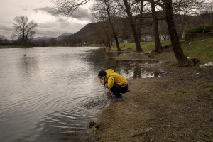 A migrant washes his face in the waters of Una river in Bihac, Bosnia and Herzegovina on January 21, 2021. Lots of migrants avoid staying inside the Bosnian official refugee camps because of the hard conditions in which they are forced to live and also because the people hosted in the official camps  cannot go out freely.