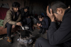 Migrants cook inside an abandoned building in Bihac, Bosnia and Herzegovina on January 21, 2021. Lots of migrants avoid staying inside the Bosnian official refugee camps because of the hard conditions in which they are forced to live and also because the people hosted in the official camps  cannot go out freely.