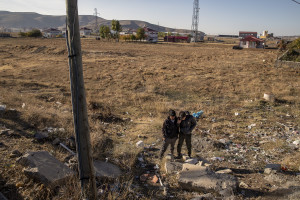 Rahmatullah, 18 years old (left) and Erfanullah, 17 years old (right) from Kabul, Afghanistan talk to a smuggler on the phone near a gas station as they wait to continue their journey to Istanbul in Bitlis, Turkey on October 22, 2021. Erfanullah and Rahmatullah have been in Turkey for a month and a half and have paid a thousand dollars each for their trip.
