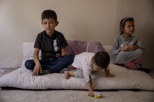 Fazel, 9 years old (left) from Takhar province, Afghanistan is seen with his brother Mohammad, 2 years old (center) and his sister Monisa, 7 years old i(right) nside the house where they live in Van, Turkey on October 25, 2021.