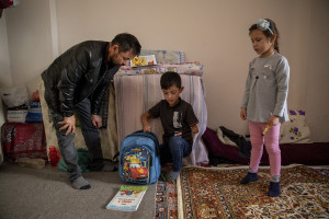 Abdul, 40 years old from Takhar province, Afghanistan helps his son Fazel, 9 years old with homework inside the house where they live in Van, Turkey on October 25, 2021. Abdul arrived in Turkey for about two months paying 7200 dollars for the entire family.