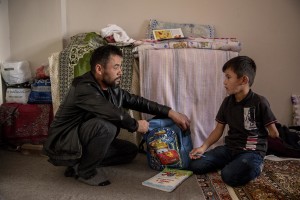 Abdul, 40 years old from Takhar province, Afghanistan helps his son Fazel, 9 years old with homework inside the house where they live in Van, Turkey on October 25, 2021. Abdul arrived in Turkey for about two months paying 7200 dollars for the entire family.