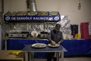 Mohammed, 38 years old from Parwan province, Afghanistan at work inside a fish shop in Van, Turkey on October 24, 2021. Mohammed arrived in Turkey for about a month and a half with his two wives and his five children paying 7200 dollars for the entire family.