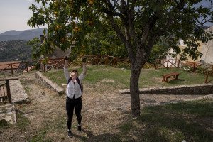 A woman picks an orange from a tree during a guided tour in Cuccaro Vetere, Southern Italy on October 1, 2021. Cuccaro Vetere is a small village of just over five hundred inhabitants in the Salerno area considered “blue zone”, that is one of those places where people live longer than the average.