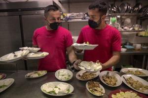 People at work inside the kitchen of “Al Sentiero” farmhouse in Galdo, Southern Italy on October 3, 2021.