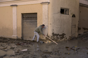 A man searches for something in the mud using a stick two days after a landslide hit the Italian holiday island of Ischia, Southern Italy on November 28, 2022.