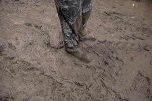 A man is seen with his feet in the mud the day after a landslide hit the Italian holiday island of Ischia, Southern Italy on November 27, 2022.