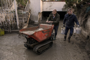 Two men at work removing mud from a garage two days after a landslide hit the Italian holiday island of Ischia, Southern Italy on November 28, 2022.