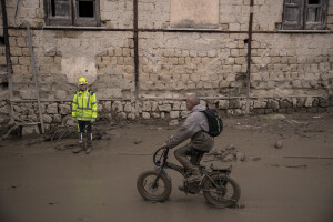 A man on a bicycle rides along a mud-covered road two days after a landslide hit the Italian holiday island of Ischia, Southern Italy on November 28, 2022.