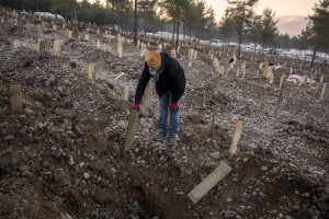 A man stands among graves in a cemetery where victims of the deadly earthquake are buried in Kahramanmaras, Turkey on February 13, 2023. On February 6, 2023 a powerful earthquake measuring 7.8 struck southern Turkey killing more than 50,000 people.