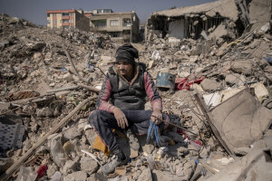 A man sits on the rubble of a destroyed building in Kahramanmaras, Turkey on February 18, 2023. On February 6, 2023 a powerful earthquake measuring 7.8 struck southern Turkey killing more than 50,000 people.