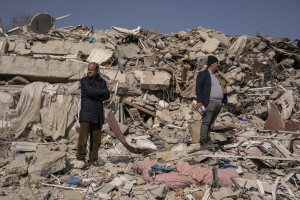 Two men stand on the rubble of a collapsed building in Hatay, Turkey on February 12, 2023. On February 6, 2023 a powerful earthquake measuring 7.8 struck southern Turkey killing more than 50,000 people.