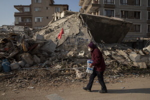 A woman carries bottles of water in Hatay, Turkey on February 12, 2023. On February 6, 2023 a powerful earthquake measuring 7.8 struck southern Turkey killing more than 50,000 people.