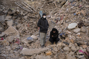Two men are seen waiting for rescuers to extract the lifeless bodies of their family members in Kahramanmaras, Turkey on February 16, 2023. On February 6, 2023 a powerful earthquake measuring 7.8 struck southern Turkey killing more than 50,000 people.