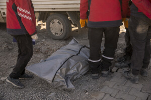 Workers are seen near a black bag containing the corpse of a person extracted from the rubble of a building in Kahramanmaras, Turkey on February 13, 2023. On February 6, 2023 a powerful earthquake measuring 7.8 struck southern Turkey killing more than 50,000 people.