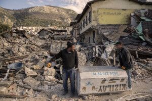 A man and his son carry an object taken from their earthquake-destroyed home in Hatay, Turkey on February 15, 2023. On February 6, 2023 a powerful earthquake measuring 7.8 struck southern Turkey killing more than 50,000 people.