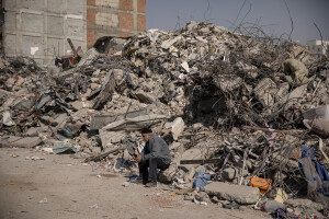 A man sits on the rubble of a destroyed building in Kahramanmaras, Turkey on February 18, 2023. On February 6, 2023 a powerful earthquake measuring 7.8 struck southern Turkey killing more than 50,000 people.