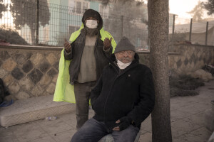 A man prays while another man sits in the center of Kahramanmaras, Turkey on February 16, 2023. On February 6, 2023 a powerful earthquake measuring 7.8 struck southern Turkey killing more than 50,000 people.