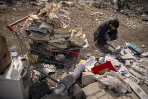 A Syrian man looks at some photographs as he waits for rescuers to extract the lifeless bodies of his family members in Kahramanmaras, Turkey on February 19, 2023. On February 6, 2023 a powerful earthquake measuring 7.8 struck southern Turkey killing more than 50,000 people.