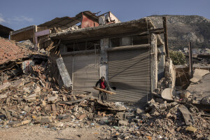 A man holds a piece of wood near the rubble of destroyed buildings in Hatay, Turkey on February 15, 2023. On February 6, 2023 a powerful earthquake measuring 7.8 struck southern Turkey killing more than 50,000 people.