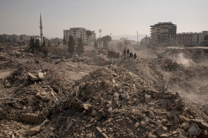 People stand on the rubble of destroyed buildings in Kahramanmaras, Turkey on February 18, 2023. On February 6, 2023 a powerful earthquake measuring 7.8 struck southern Turkey killing more than 50,000 people.