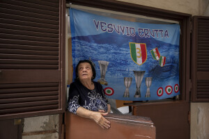 A woman is portrayed near a flag with the slogan “Vesuvius erupts” at Spanish neighborhoods in Naples, Southern Italy on April 24, 2023.