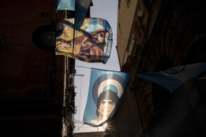 A flag of the patron saint of Naples Saint Januarius and a flag of the argentine soccer legend Diego Armando Maradona hang on the buildings of the historic center of Naples, Southern Italy on April 6, 2023.