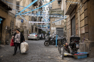 A woman walks through the streets decorated in blue to celebrate the victory of Napoli’s third championship at Spanish neighborhoods in Naples, Southern Italy on April 24, 2023.