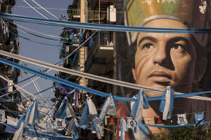 A mural depicting the patron saint of Naples Saint Januarius is seen amid banners and blue flags to celebrate the Napoli football club’s third Scudetto victory in the Forcella district in Naples, Southern Italy on April 20, 2023.