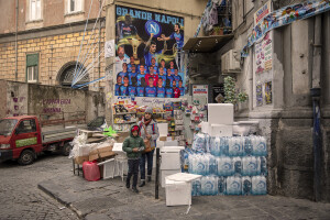 A mother and her son walk near a poster of the Napoli football team in Sanità district in Naples, Southern Italy on April 6, 2023.