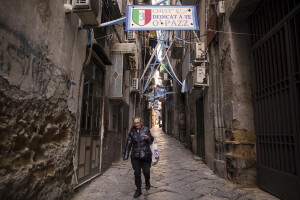 A woman walks through the streets decorated in blue to celebrate the victory of Napoli’s third championship in the historical center of Naples, Southern Italy on April 20, 2023.