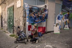 A woman photographs her son at Spanish neighborhoods in Naples, Southern Italy on April 24, 2023.