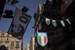 Photographs of the players of the Napoli soccer team and tricolor badges hang between the buildings of the historical center of Naples, Southern Italy on April 20, 2023.