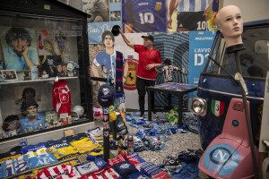 A man is seen near the shirts, photographs and all the memorabilia of Argentine footballer Diego Armando Maradona at Spanish neighborhoods in Naples, Southern Italy on April 24, 2023.