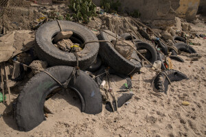 Wheels tied together and used as a barrier to stop the sea waves are seen on the beach of Bargny, Senegal on December 16, 2023. The coastal erosion began in the 1980s but worsened in the early 2000s. Storm surges have become more common and fiercer, like the passage of Hurricane Fred in the night of August 30, 2015. Bargny is currently losing three to four meters of coast each year.