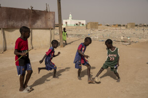 Children play football inside the Khar Yalla temporary settlement for internally displaced people who lost their homes due to coastal erosion in Saint-Louis, Senegal on December 13, 2023. Khar Yalla camp is a mix of small concrete houses and tents located in an empty field far from the city center.