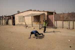 Two children play football inside the Khar Yalla temporary settlement for internally displaced people who lost their homes due to coastal erosion in Saint-Louis, Senegal on December 13, 2023. Khar Yalla camp is a mix of small concrete houses and tents located in an empty field far from the city center.