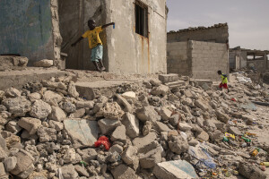 Two kids are seen near some houses heavily damaged by the sea in Bargny, Senegal on December 16, 2023. The coastal erosion began in the 1980s but worsened in the early 2000s. Storm surges have become more common and fiercer, like the passage of Hurricane Fred in the night of August 30, 2015. Bargny is currently losing three to four meters of coast each year.