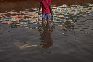 A young fisherman is seen in the water of Senegal river in Saint-Louis, Senegal on December 11, 2023. Climate change also affects fishing, a key sector in Senegal which represents 3.2% of the country’s GDP (gross domestic product). The increase in water temperatures is having repercussions on marine ecosystems (changes in the migrations and habits of many fish species) which, in addition to the intensive fishing practiced by foreign fishing boats, is reducing the country’s fish resources. Furthermore, the advance of the sea is forcing many fishermen in Saint-Louis to leave their homes facing the sea and move inland: now to reach the sea and go fishing they have to face long and expensive journeys.