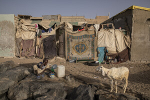 A child washes his face in front of his house facing the sea in the “Langue de Barbarie” in Saint-Louis, Senegal on December 14, 2023. The “Langue de Barbarie” is a thin, sandy peninsula located in western Senegal, where around 80,000 people live and is among the places most threatened by the rise in sea levels generated by climate change. The peninsula separates the Atlantic ocean from the final section of the Senegal river.