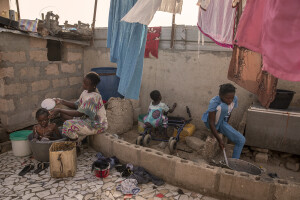 Bayo, 24 years old bathes her daughter, while her other two daughters play in the house where they live inside the Khar Yalla temporary settlement for internally displaced people who lost their homes due to coastal erosion in Saint-Louis, Senegal on December 13, 2023. Khar Yalla camp is a mix of small concrete houses and tents located in an empty field far from the city center.