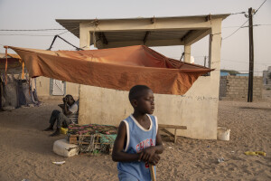 A child and a man are seen inside the Djougop temporary camp for internally displaced people who lost their homes due to coastal erosion in Saint-Louis, Senegal on December 13, 2023. At Djougop temporary camp located seven miles inland people live in small tents without bathrooms and electricity. Toilets and taps for running water are shared.